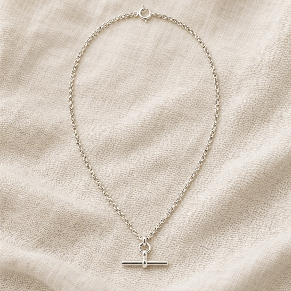 Silver T-Bar Chain laid flat on natural linen, full necklace and T-bar pendant