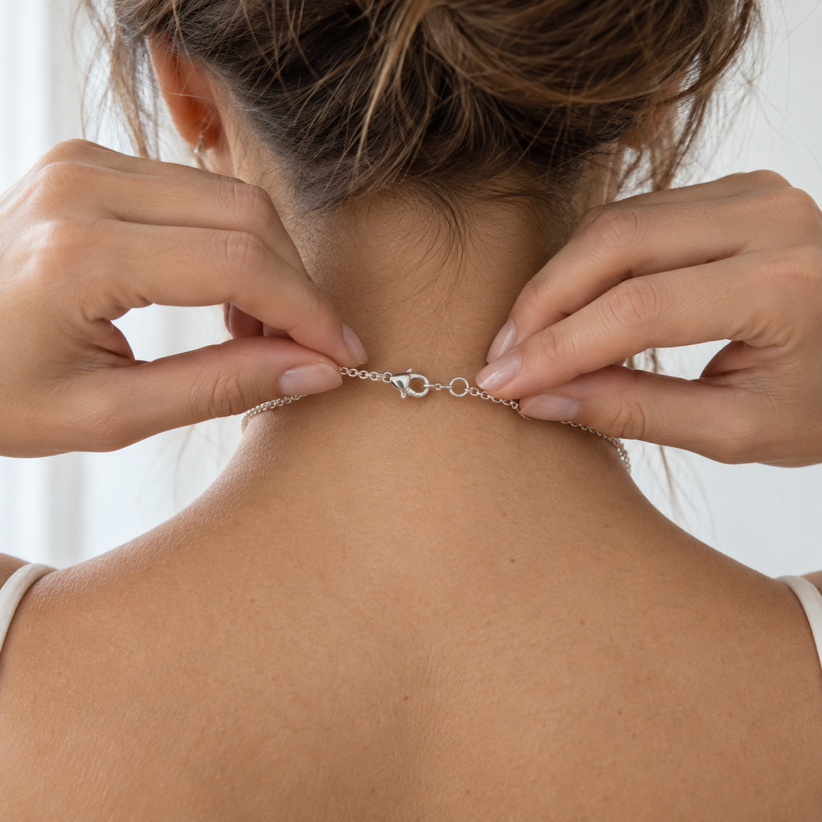 Close detail of the Silver T-Bar Chain clasp fastened at the back of the neck